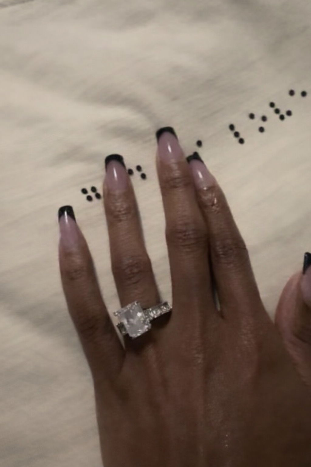 Close-up of fingers touching the braille on the God Is Love tee